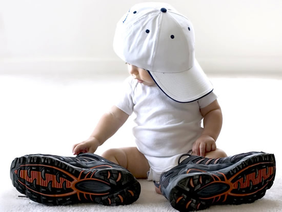Immagini con i bambini - Un bimbo che indossa scarpe grandi ed un cappello