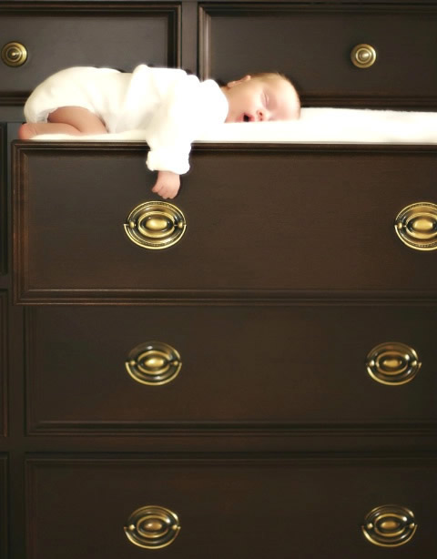Un neonato che dorme nei cassetti del comò