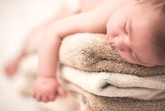 Bambino che dorme sugli asciugamani